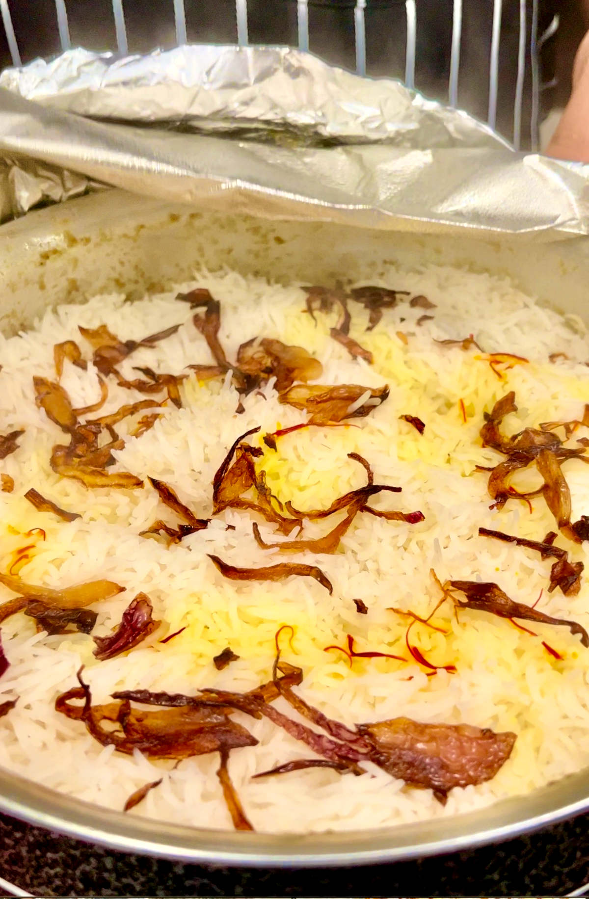 uncovering the cooked biryani rice