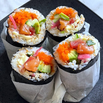 close up shot of four sushi burritos on a plate