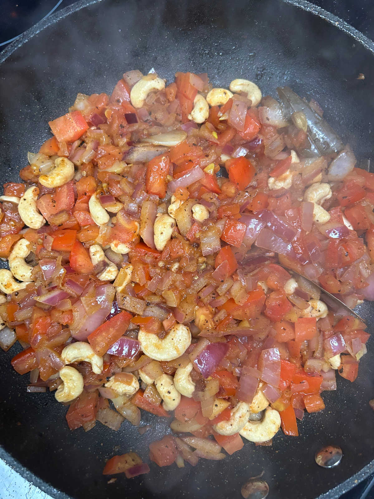 Chopped and diced ingredients for butter chicken in a pan.