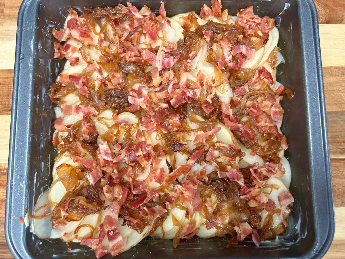 baking dish with a mixture of potatoes bacon and caramelized onions