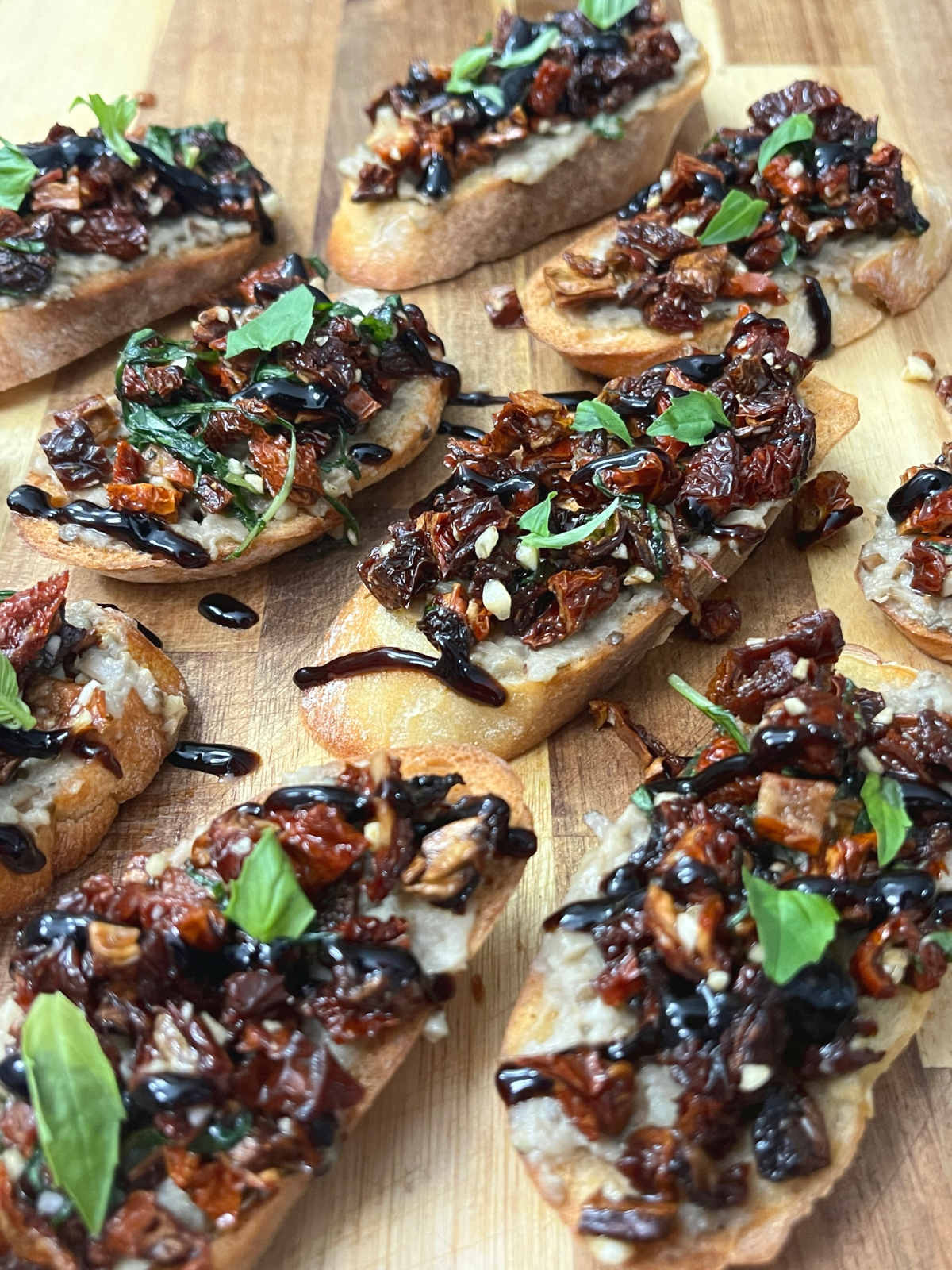 A couple of Baba Ganoush Bruschettas placed diagonally on a cutting board