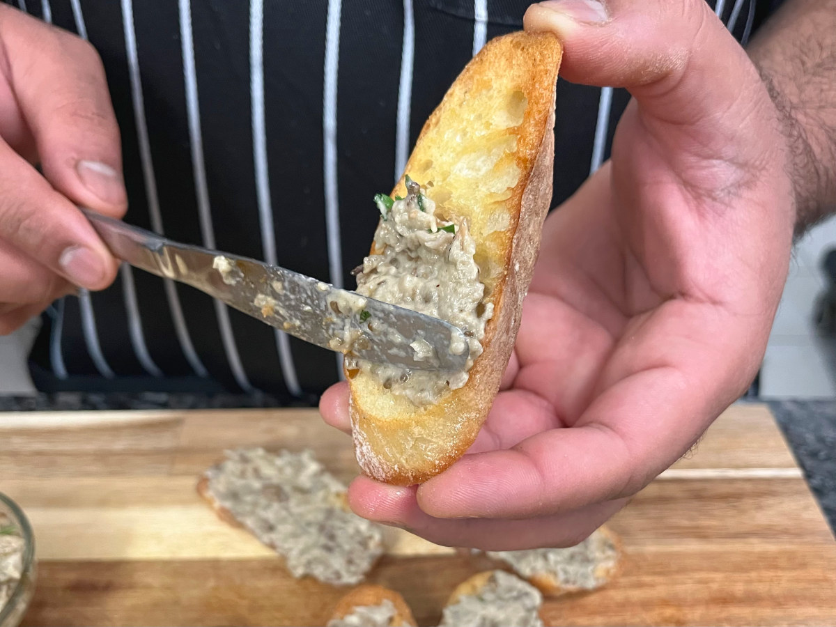 Applying Baba Ganoush on the sliced baguette