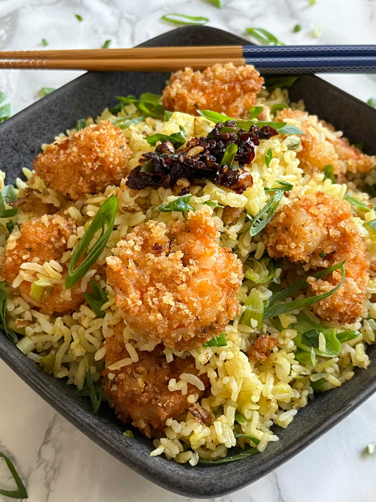 Shrimp fried rice in a bowl with chopsticks on the side