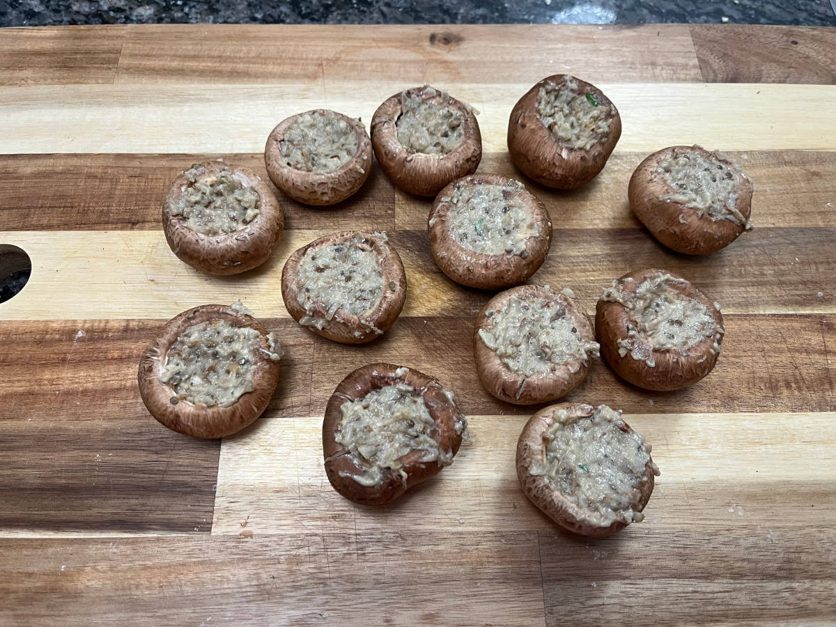 mushrooms stuffed with baba ganoush on a cutting board