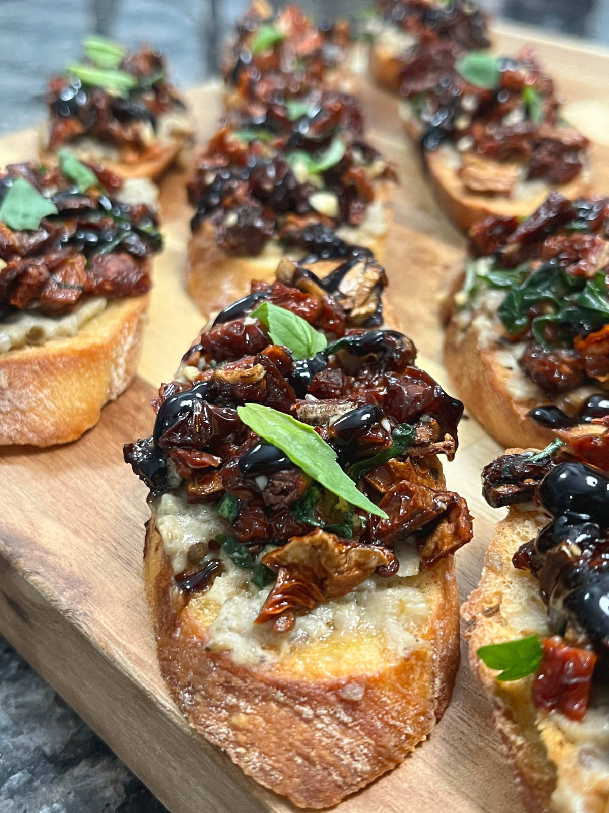 A couple of Baba Ganoush Bruschettas placed vertically on a cutting board.