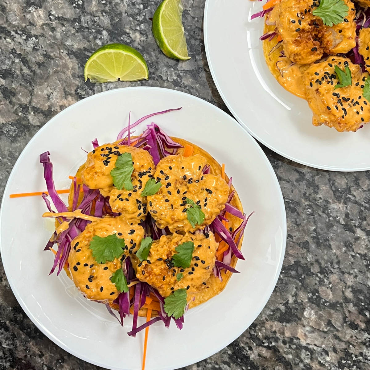 Two plates of prawn Thai curry tostadas with two slices of lime on the side