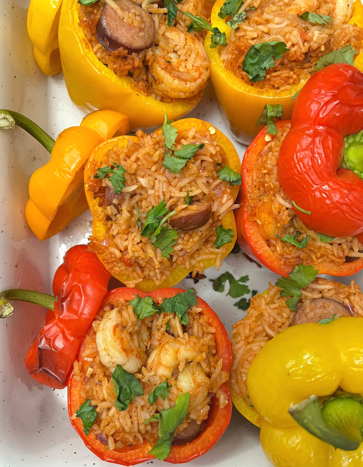 six jambalaya stuffed peppers in a baking dish