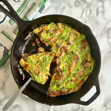 lomo saltado frittata in a skillet with a fork