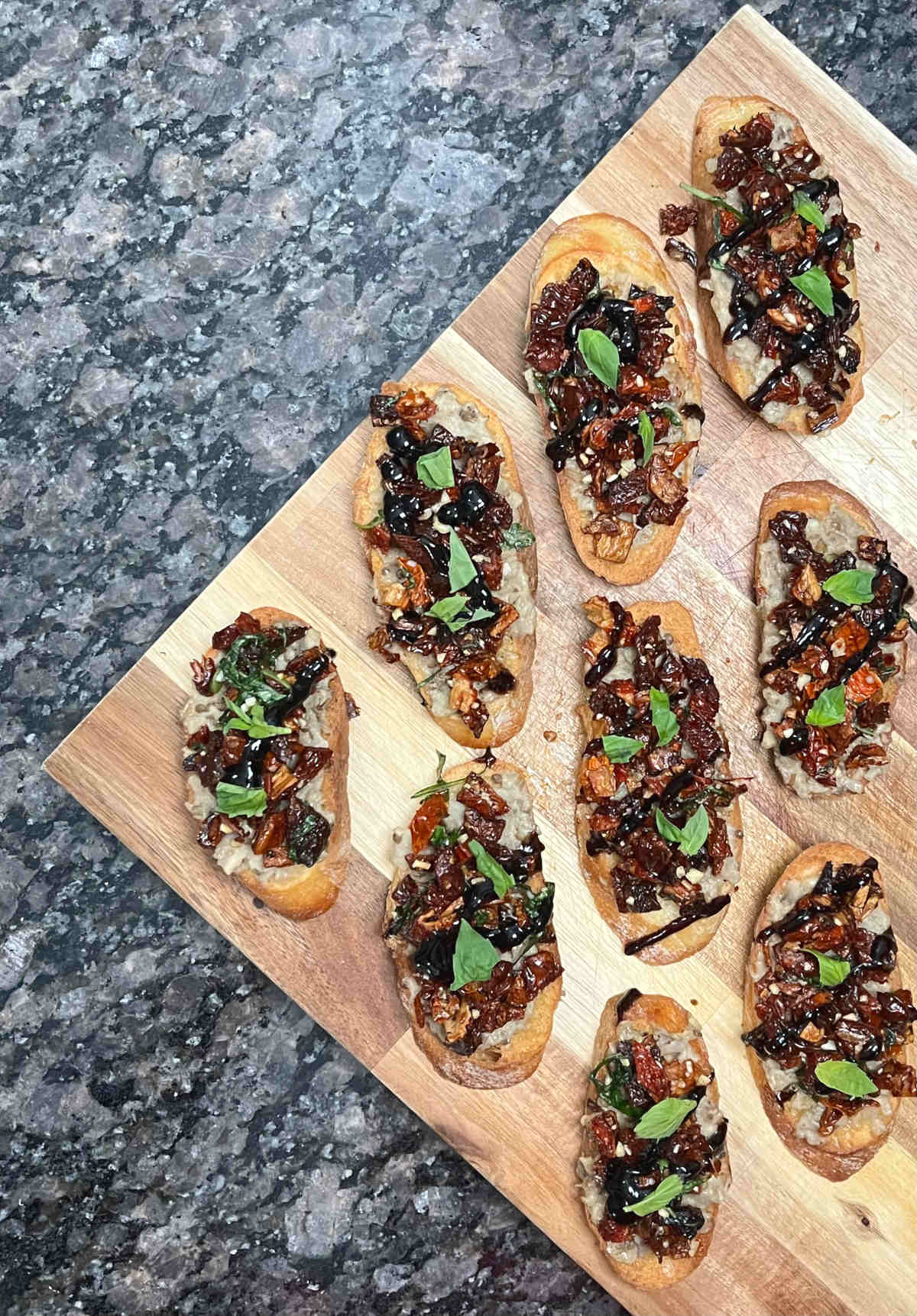 A couple of Baba Ganoush Bruschettas placed vertically on a cutting board