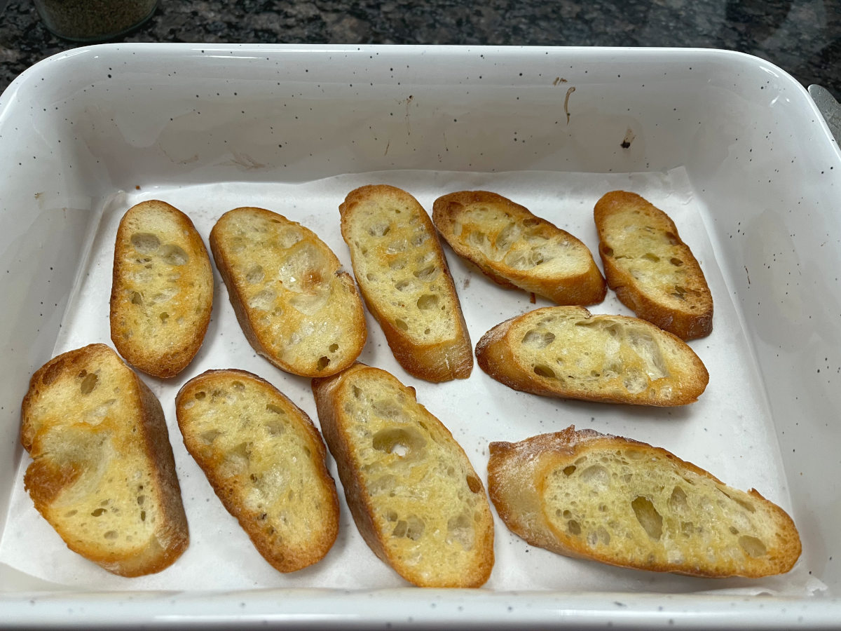 Toasted sliced baguettes in a baking tray