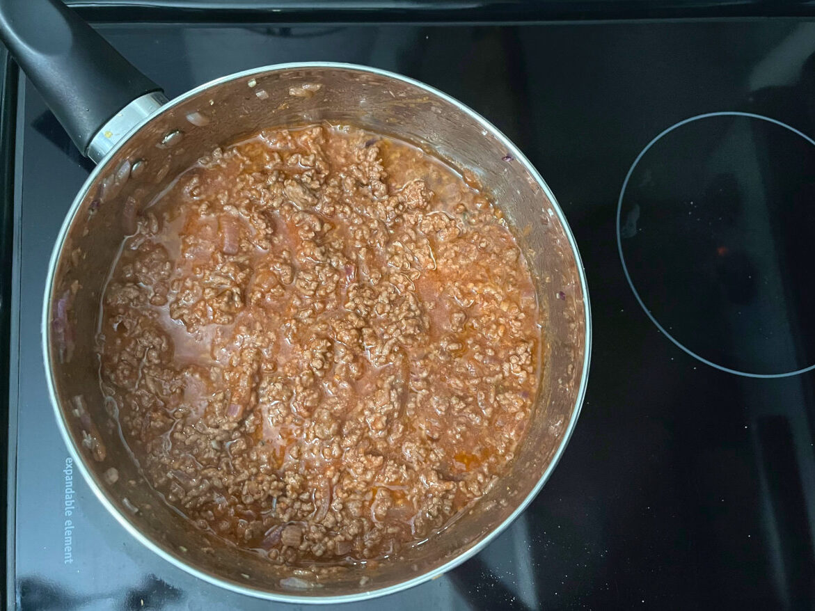 ground beef with sauce cooking in a pan