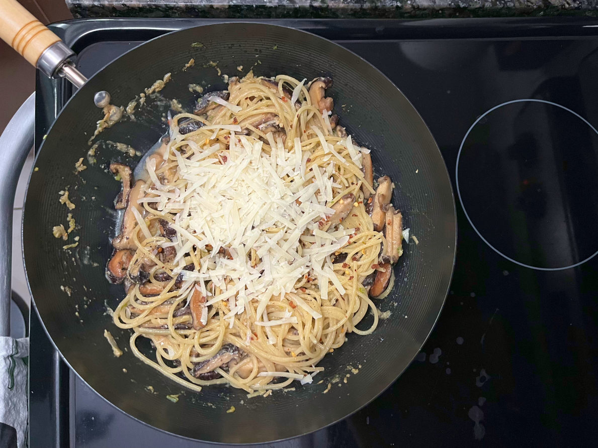 parmesan cheese added to the wok with the miso mushroom pasta