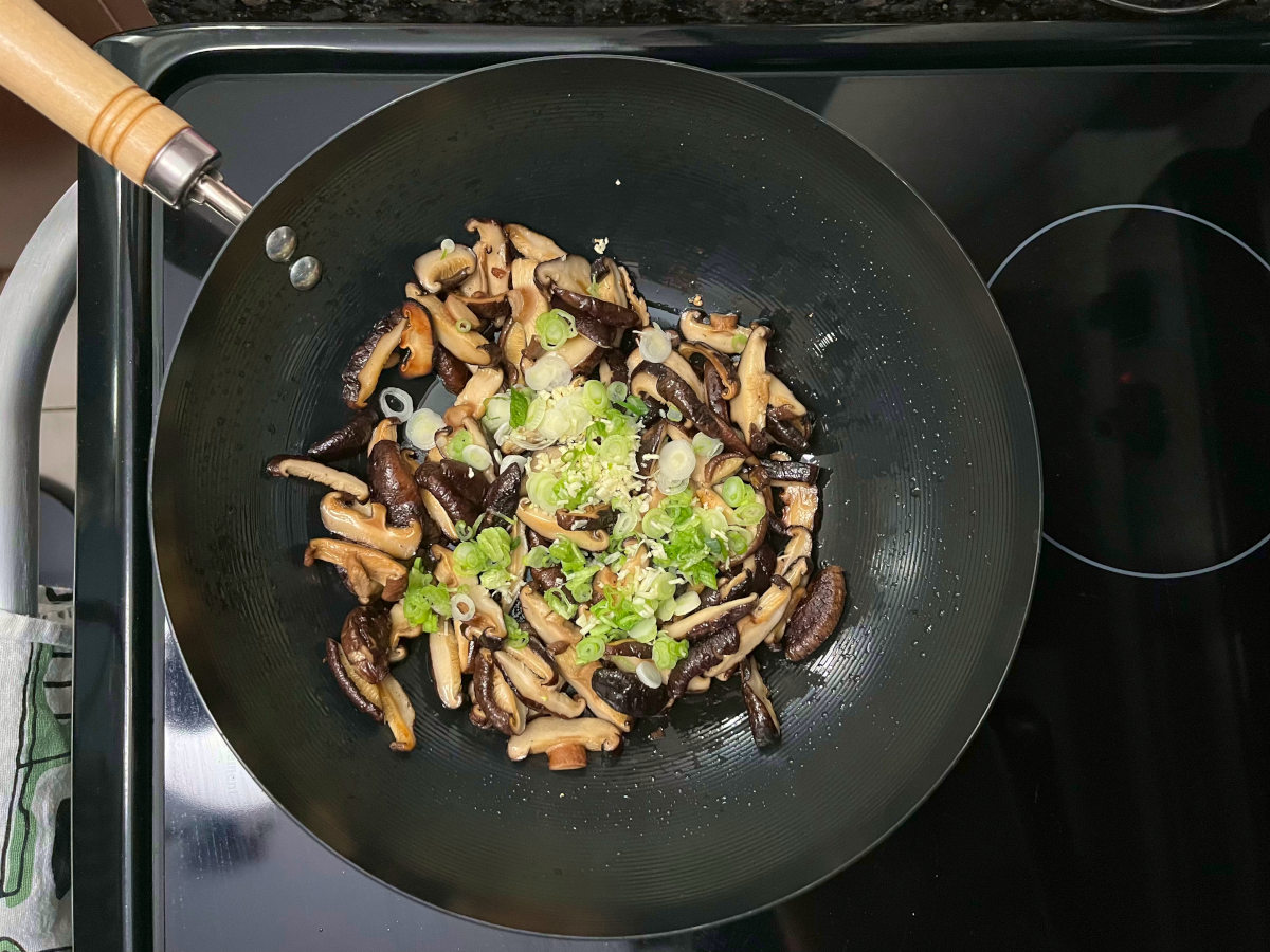 mushrooms, spring onions and garlic sautéed in a wok.