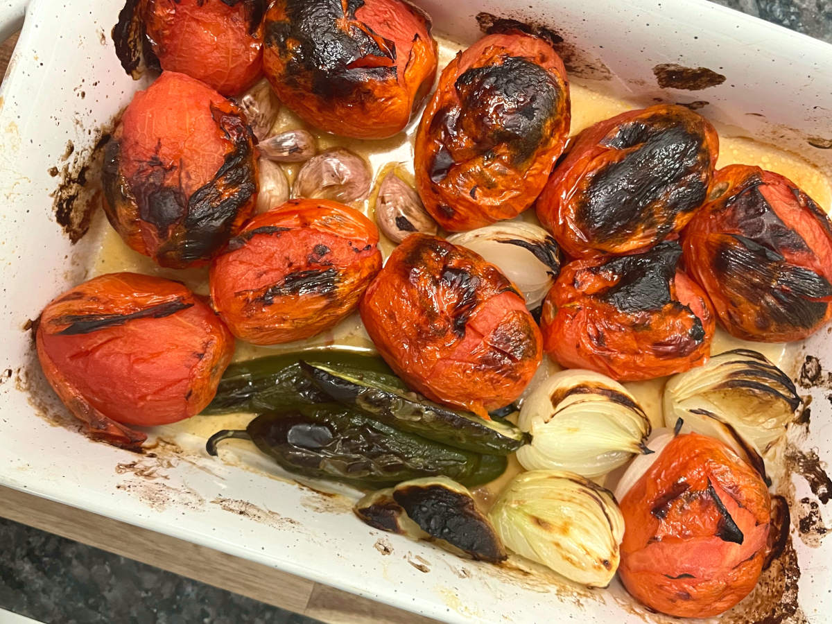 Charred tomatoes, jalapenos, onions and garlic in a baking dish