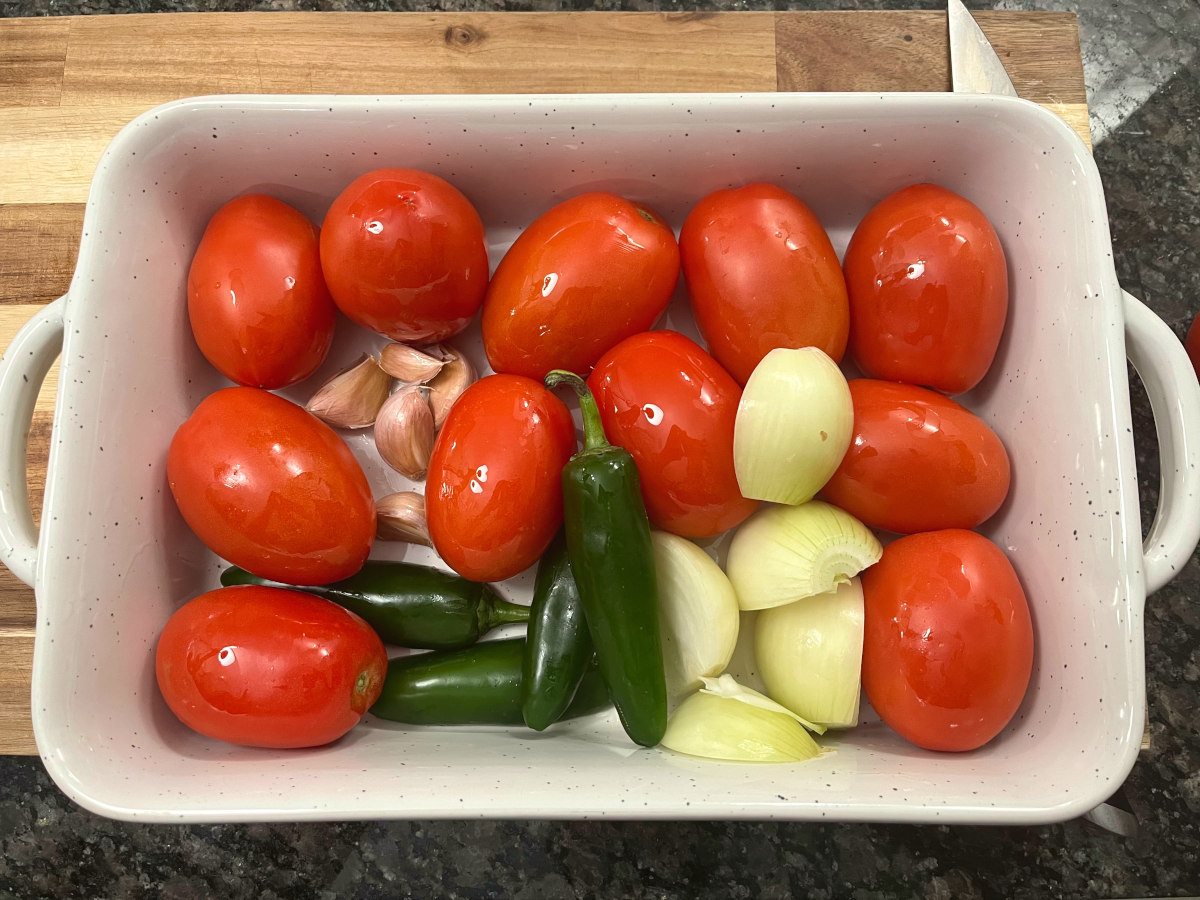 Tomatoes, jalapenos, onions and garlic in a baking dish