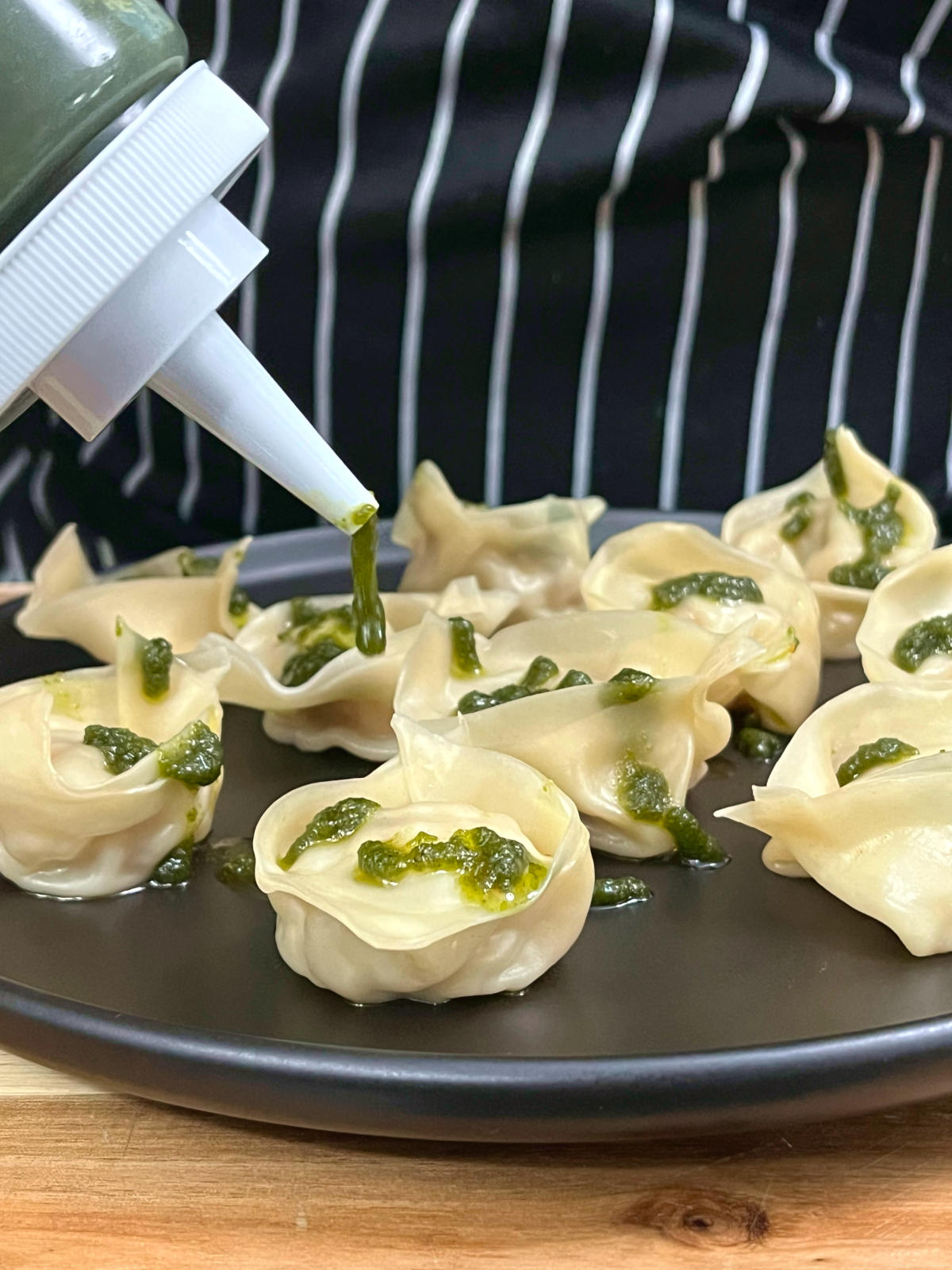 pesto sauce drizzled on shrimp wontons