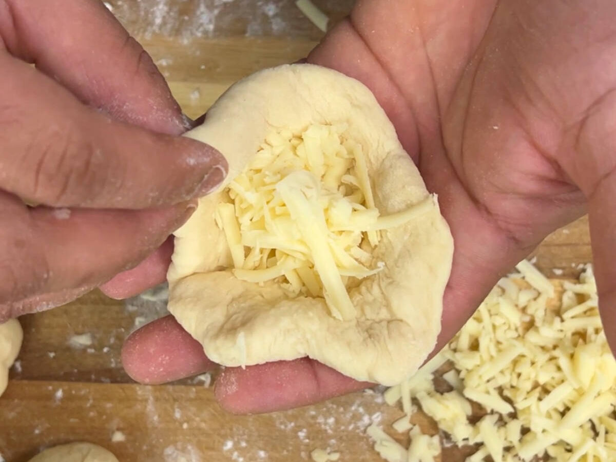 Cheese filled into one of the dough pieces to form the bun