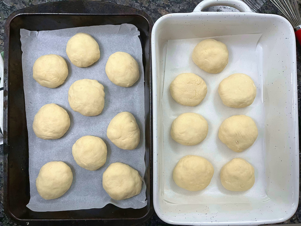 Two baking trays filled with cheese buns