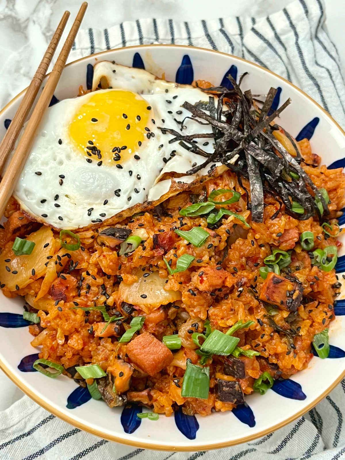 kimchi fried rice in a bowl with chopsticks on the side