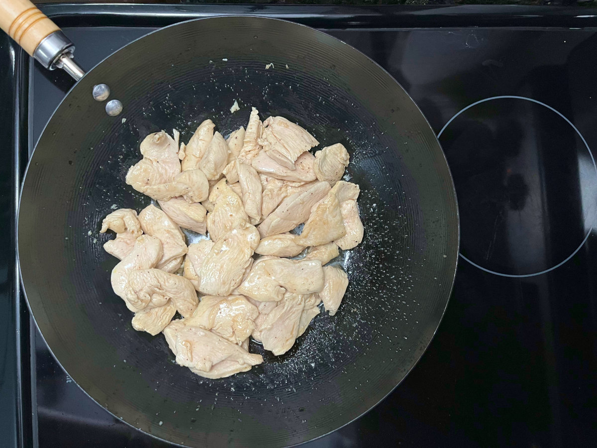 stir frying chicken in a wok