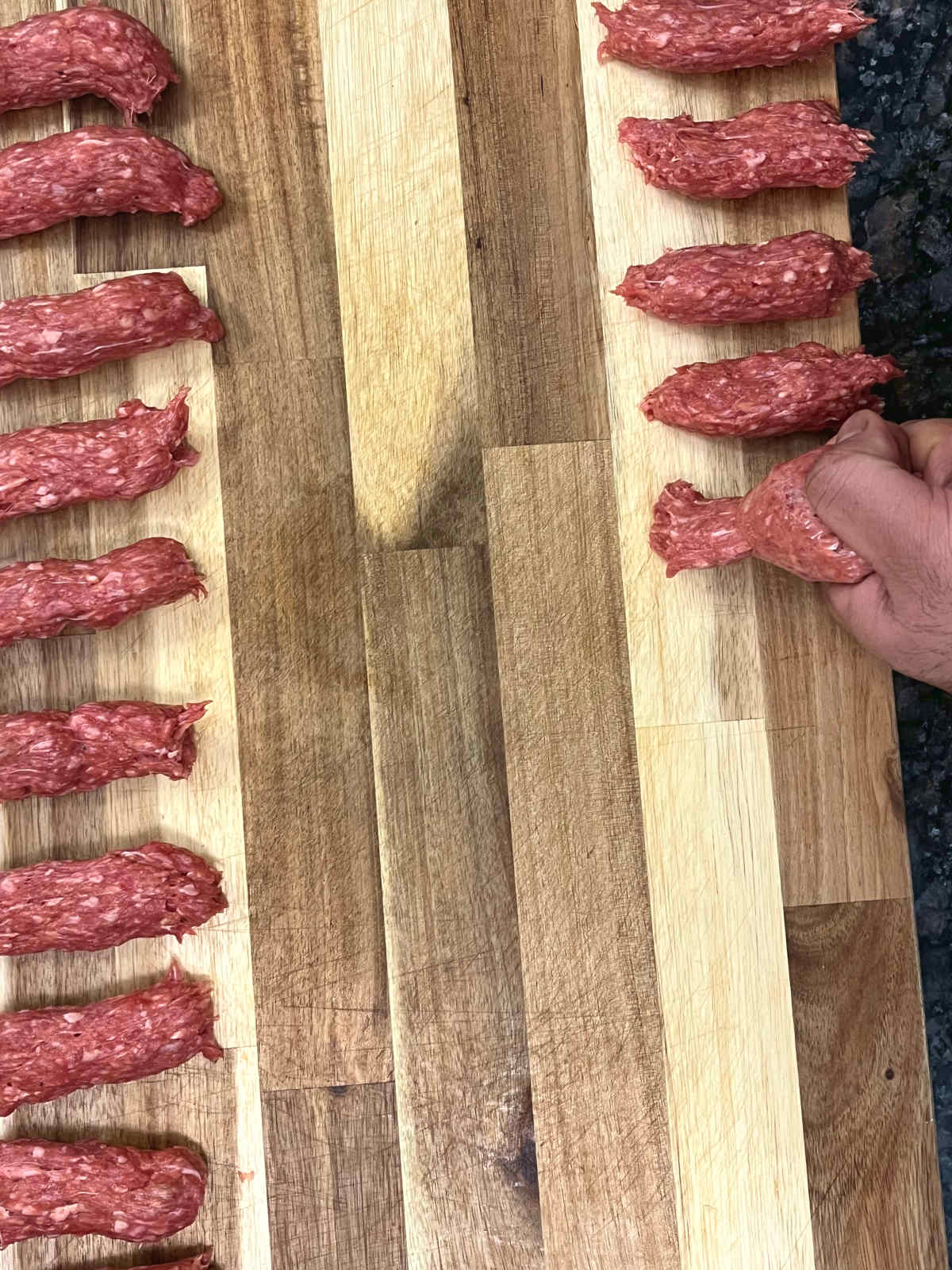raw Balkan sausages on a board