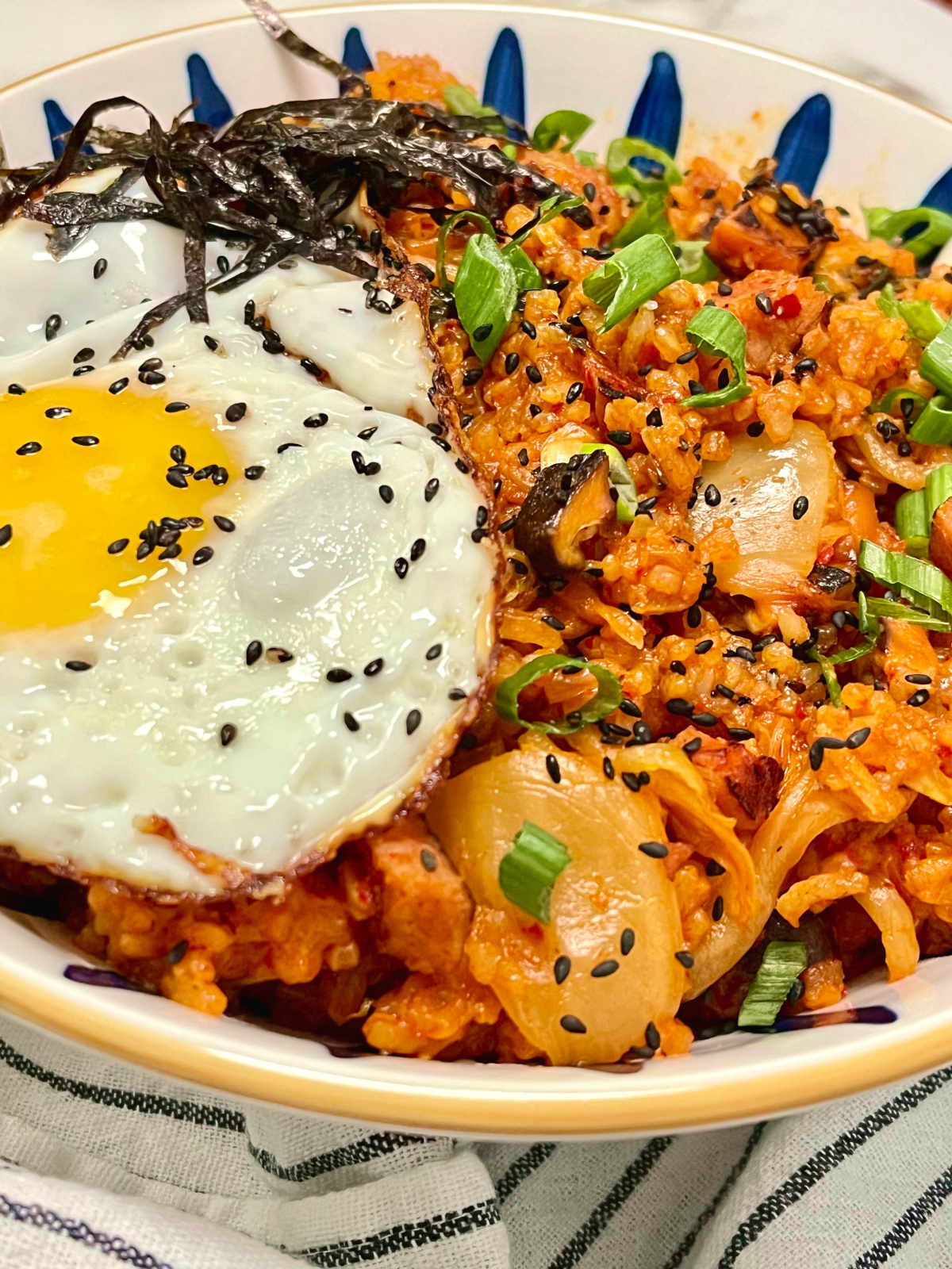 kimchi fried rice in a bowl topped with egg and nori