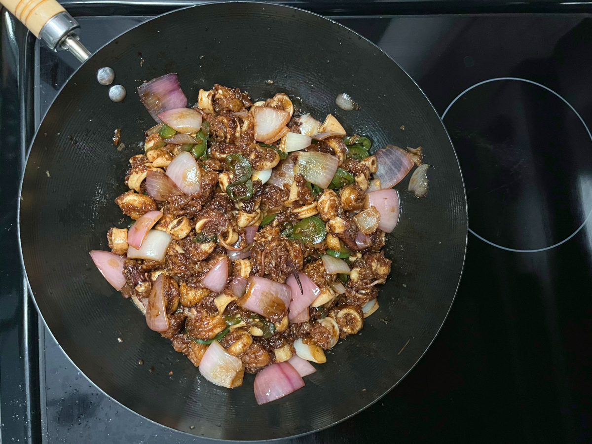 all ingredients in a wok with sauces added on top