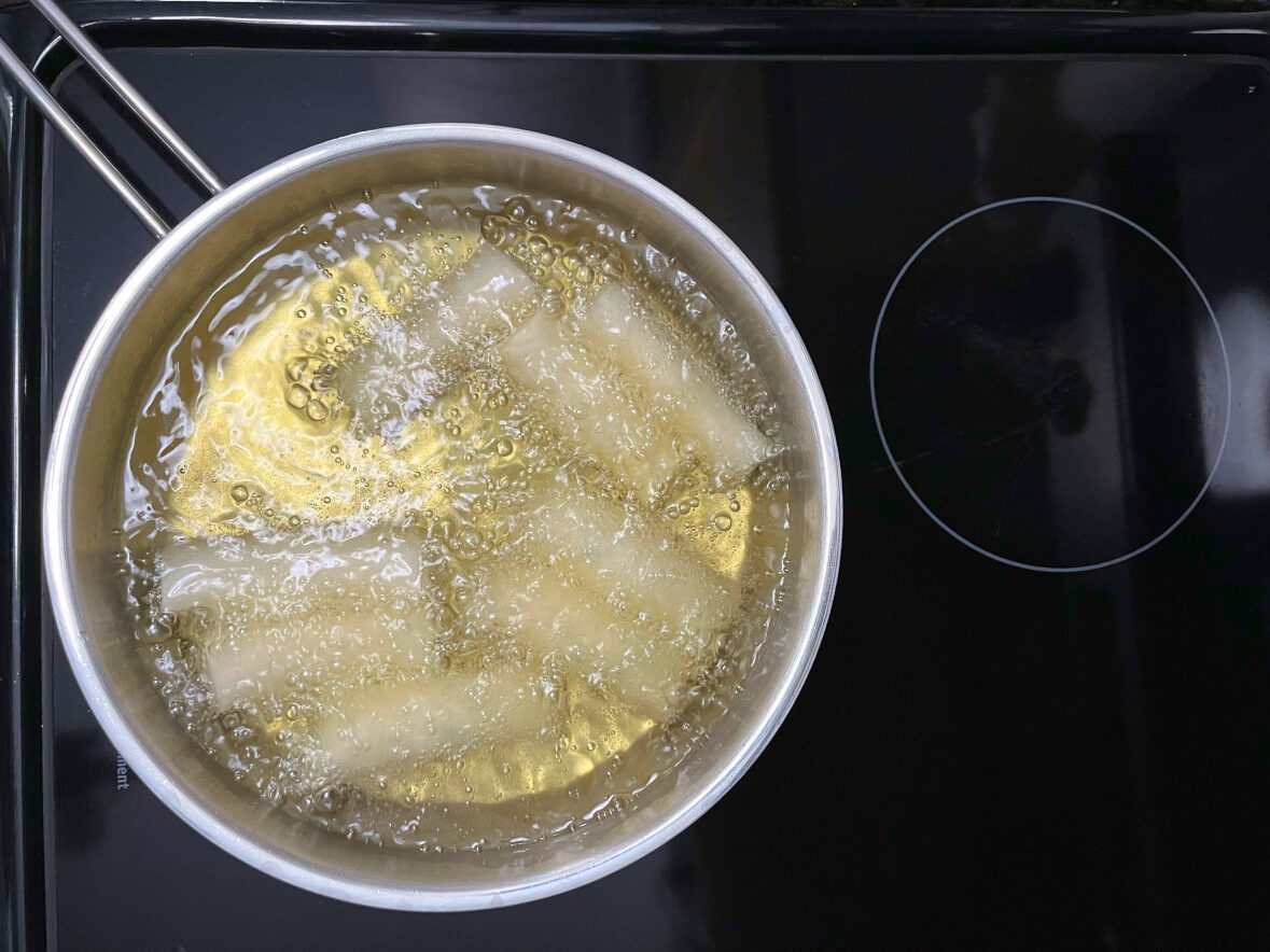 filled rolls deep frying in a pan