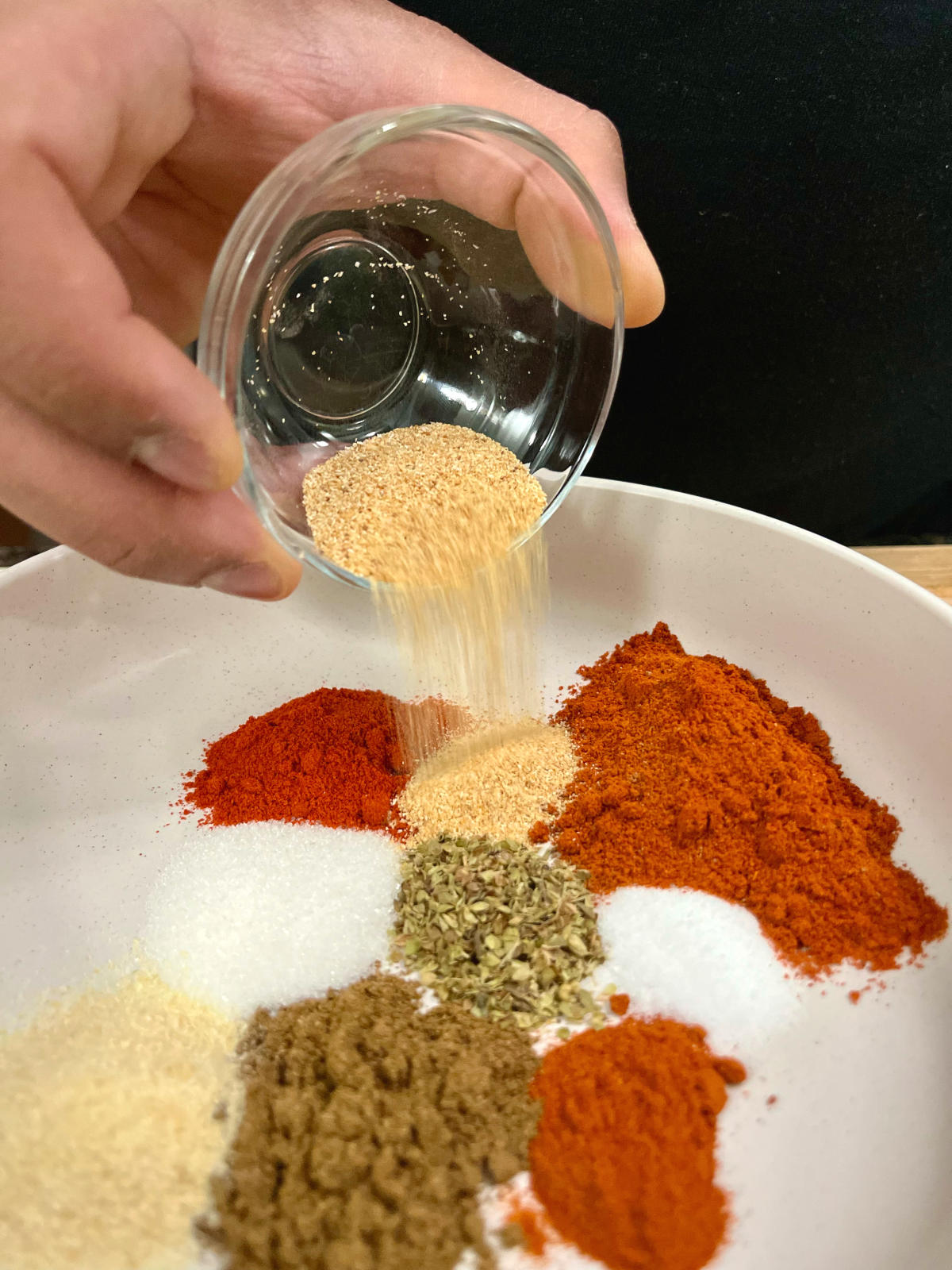 pouring an ingredient into a bowl that contains other ingredients of the recipe