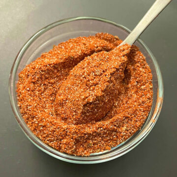 fajita seasoning scooped from a bowl with a spoon
