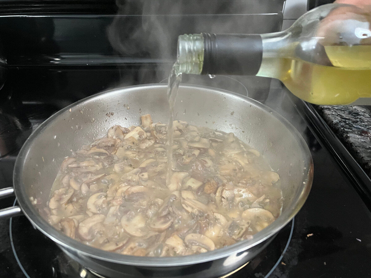 pouring white wine to the pan