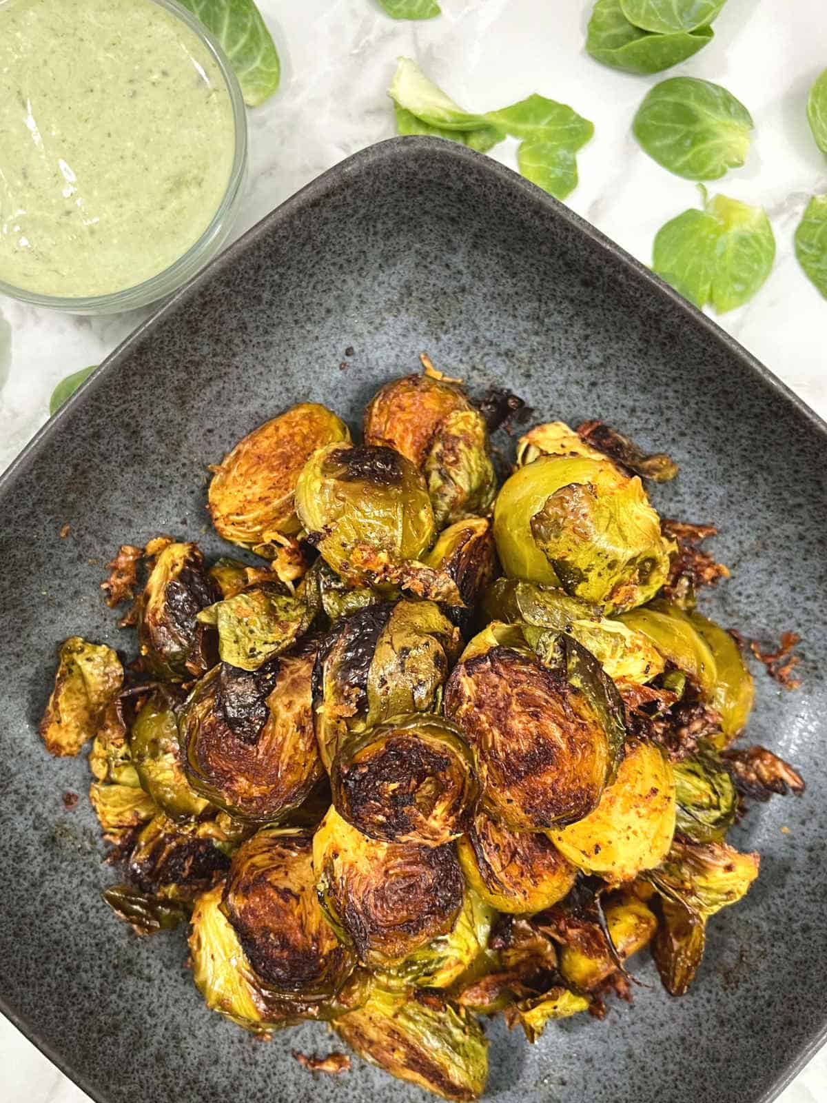 Indian brussels sprouts in a bowl with mint chutney in a smaller bowl on the side