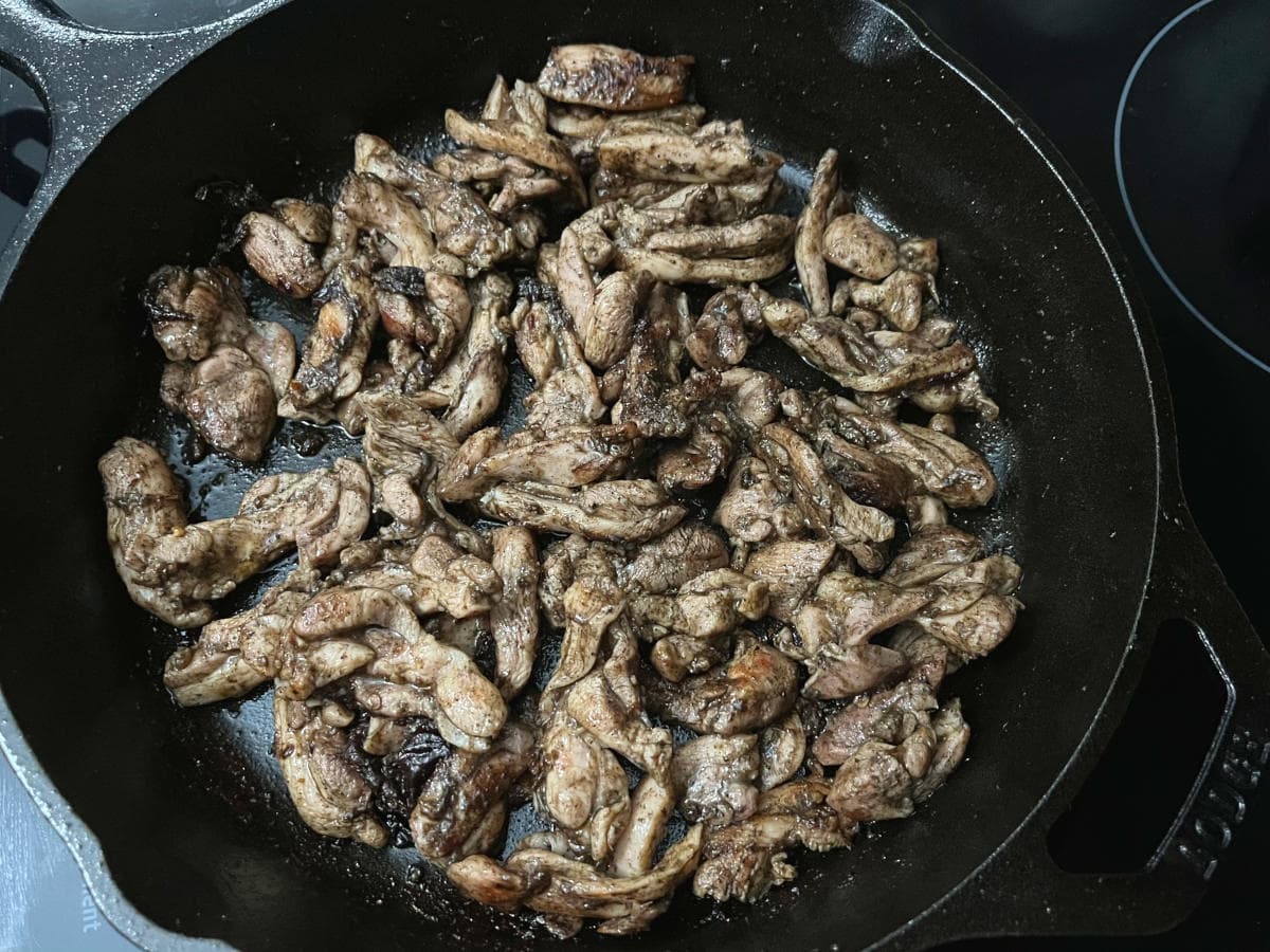 jerk chicken frying in a skillet