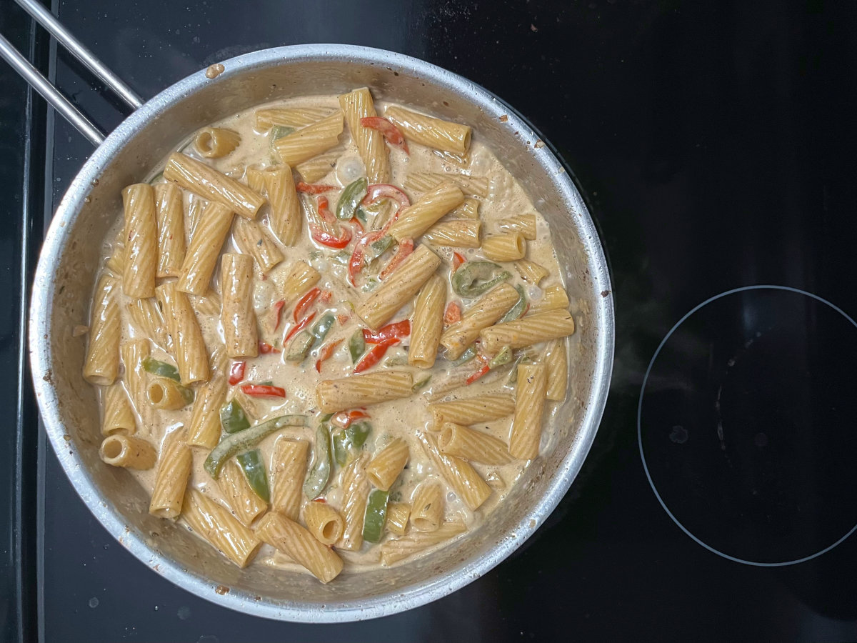 cooked pasta mixed with the sauce in a pan