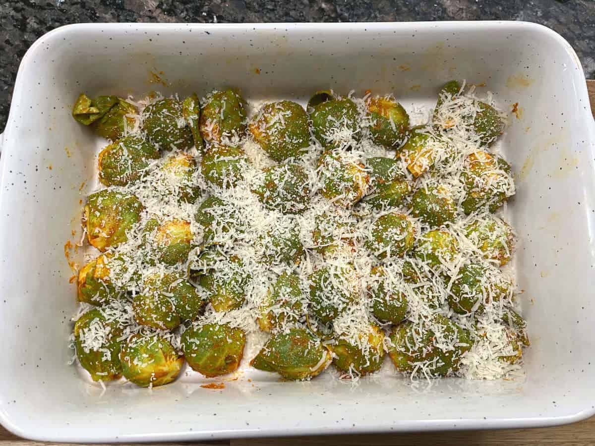 brussels sprouts in a baking dish topped with parmesan cheese