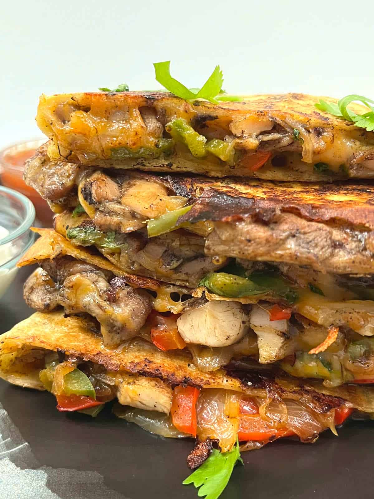 slices of jerk chicken quesadilla stacked on a plate