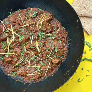 Beef karahi in a pan with roti on the side